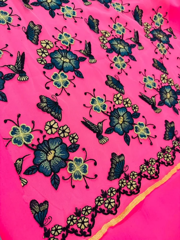 Detalle de bordado floral sobre tela rosada